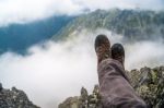 Trekker Over The Clouds In The Mountains Stock Photo