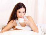 Woman Holding Cup Of Coffee In Bed Stock Photo