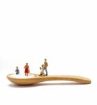 Miniature Little Children Standing On A Wooden Spoon And Thinking Of Sugar, Diet, Fat And Diabetes. Health Care Concept Stock Photo