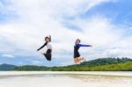 Two Asian Teen Girls Friends Jumping Enjoy On The Beach Stock Photo