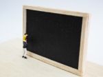 Miniature Children Standing In Front Of A Blackboard On Wooden B Stock Photo