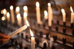 Woman Lighting Prayer Candle Stock Photo