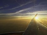 Sun Set On Horizon Cloud Sky  Through Airplane Wing Stock Photo