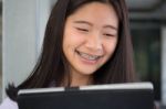 Portrait Of Thai Student Teen Beautiful Girl Using Her Tablet Stock Photo