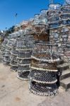 Lobster Pots Stacked Against The Harbour Wall In Brixham Stock Photo