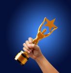 Star Award In Hand Isolated On Blue Background Stock Photo