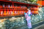 Asian Women Wearing Japanese Traditional Kimono Visiting The Beautiful In Fushimi Inari Shrine In Kyoto, Japan Stock Photo