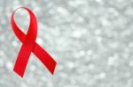 Red Ribbon Sign On Silver Bokeh Background Stock Photo
