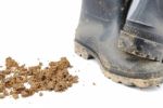 Black Rubber Boots And Soil On White Stock Photo