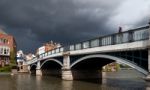 Woman Looking Over Eton Bridge As A Storm Approaches Stock Photo