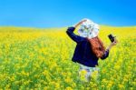 Young Woman Standing In Yellow Rapeseed Field Stock Photo