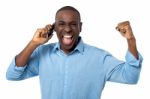 Excited African Man Talking On Mobile Phone Stock Photo