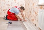 Young Handyman Installing Wooden Floor Stock Photo