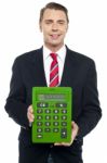 Young Businessman Showing Big Green Calculator Stock Photo