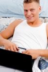 Man Keeping Laptop On His Stomach Stock Photo