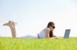 Oung Female Lying On The Grass In The Park Using A Laptop Stock Photo