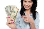 Happy Woman Holdng And Pointing Towards Dollar Notes Stock Photo
