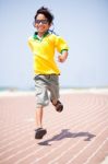 Young Kid Running On Race Track Stock Photo