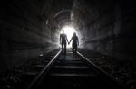 Couple Walking Together Through A Railway Tunnel Stock Photo