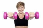 Lady Holding Pink Dumbbells. Arms Outstretched Stock Photo