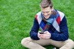 Cheerful Young Relaxed Guy Using Mobile Phone Stock Photo
