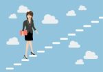 Business Woman Stepping Up A Staircase In The Sky Stock Photo