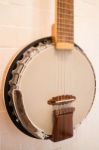 Banjo Hanging On White Brick Wall Stock Photo