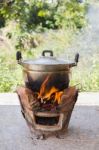 Old Aluminium Pot On Stove With Fire And Smoke, Folk Cooking Way Stock Photo