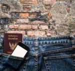 Blue Jeans With Cell Phone And Passport In A Pocket Background Stock Photo