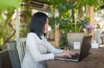 Young Asian Woman Working With Laptop In Coffee Shop Stock Photo