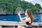 Young Woman Taking Photo Of Beautiful Sea On Camera Stock Photo