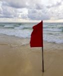 Red Warning Flag On Beach Stock Photo