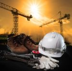 Helmet And Construction Equipment With Building And Cranes Stock Photo