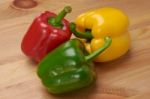 Red Green And Yellow Sweet Peppers On Table Stock Photo