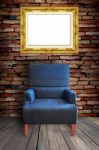 Arm Chair With Frame On Wall Stock Photo