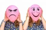 Two Girls Holding Pink Balloons With Facial Expressions Stock Photo