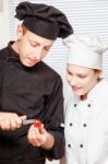 Senior Chef Teaches Young Chef To Cut Stock Photo