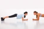 Two Happy Young Woman Doing Push-ups In Gym Stock Photo