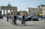 People Cycling Near The Brandenburg Gate In Berlin Stock Photo