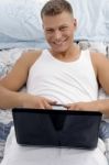 Smiling Laying Male Holding Laptop Stock Photo