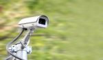Security Camera On Blur Green Plant Background Stock Photo