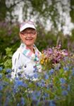 Healthy Elderly Smiling Woman With Flowers Stock Photo