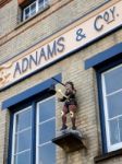 Statue Of A Boy Hitting A Bell Outside Adnam's Brewery In Southw Stock Photo