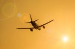 Airplane And Sunbeam With Lens Flare Effect On Orange Background Stock Photo