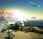 Cargo Plane Loading Commercial Goods Against Large Logistic ,shipping Port Background Stock Photo