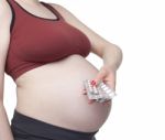 Pregnant Woman Holding Pills Stock Photo