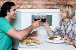 Happy Couple Clinking Their Glasses Of Wine Stock Photo