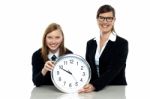 Pretty Student Holding Clock With Her Teacher Stock Photo