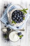 Blueberry Basket And Glass Of Yogurt On White Wooden Table Stock Photo