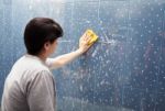 Woman Washing Tile On The Wall With A Cloth Lather Stock Photo